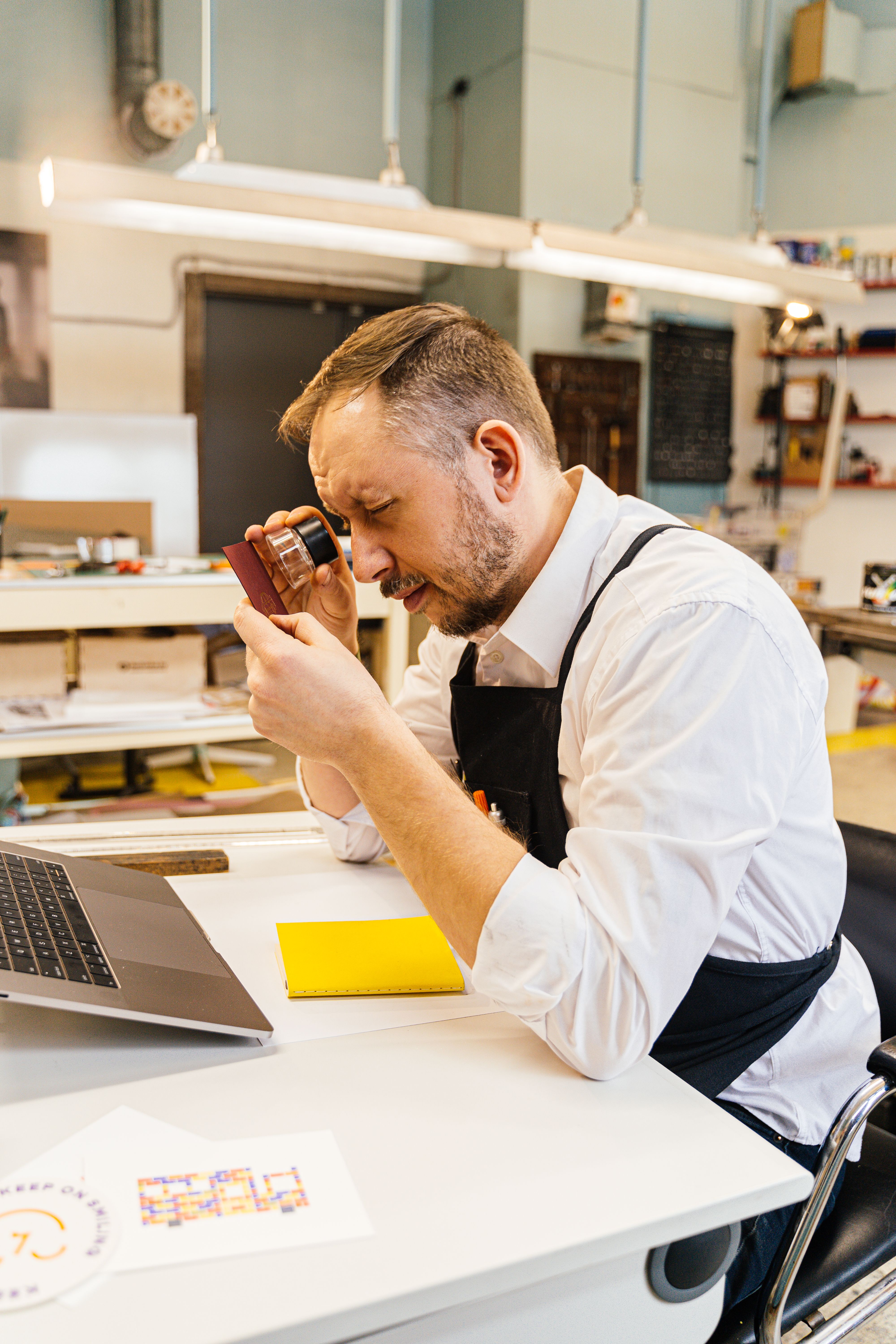 Person closely examining details with a magnifier, representing fact-checking a review