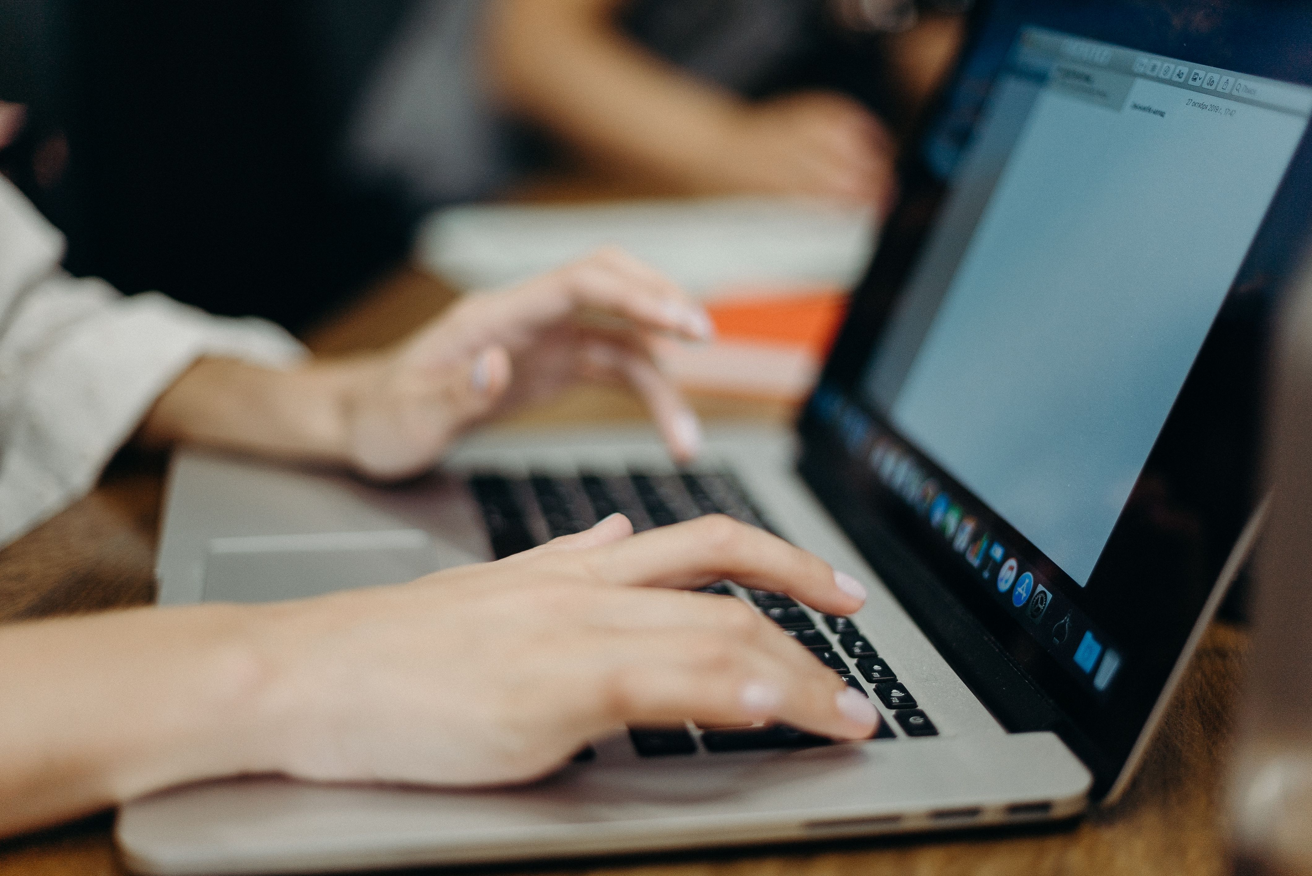 Person typing on a laptop, writing an online car review article